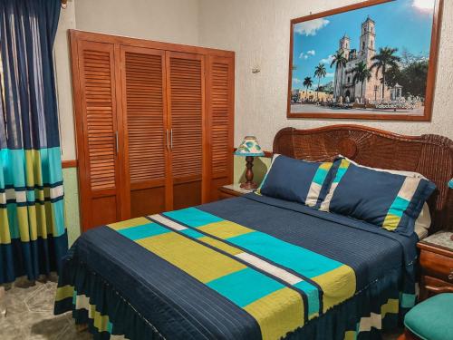 a bedroom with a bed with blue and yellow at Casa Palagui Colonial in Valladolid