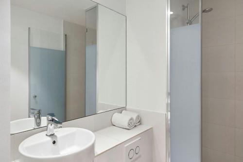 a white bathroom with a sink and a mirror at Four Points Flex by Sheraton Madrid Atocha in Madrid