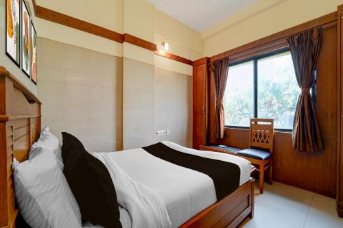 a bedroom with a bed and a window at Hotel O Stay First in Coimbatore