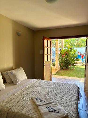 a bedroom with a bed and a door to a yard at Estalagem do Carmo in Pirenópolis