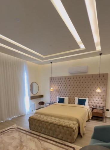 a large bedroom with a large bed and a ceiling at Villa karma in Al Rama