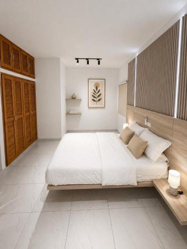 a large white bedroom with a large white bed at Silver Apartment Abidjan in Abidjan
