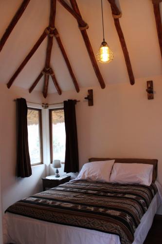 a bedroom with a bed in a room with windows at Terra Alta Lodge in Yanque