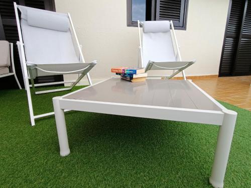 a white coffee table with two chairs and books on it at Cozy & Terrace Apartament5 in Los Cristianos