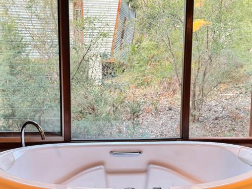a bath tub sitting in front of a window at The Odd Frog in Bright