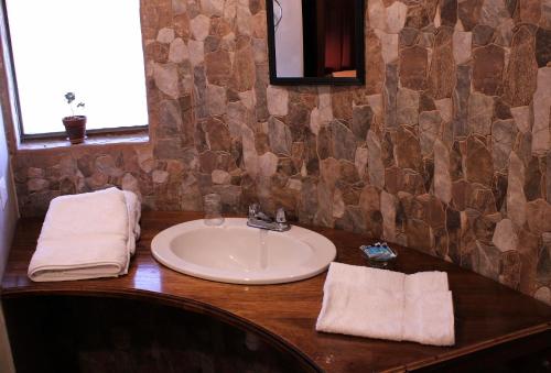 a bathroom sink with towels on a wooden counter at Terra Alta Lodge in Yanque