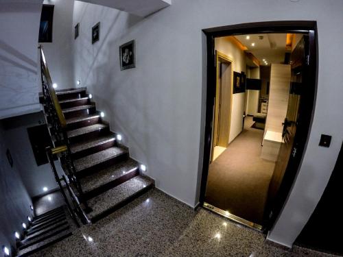 una escalera que conduce a un pasillo con puerta en SM Apartments Kopaonik, en Kopaonik