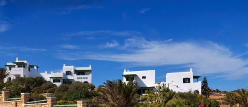a group of white buildings on top of a hill at Onar Studios in Koufonisia