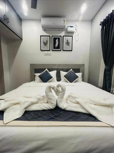 a bedroom with a large bed with a white blanket at KRS PARADISE premium suite room in Tiruvannāmalai