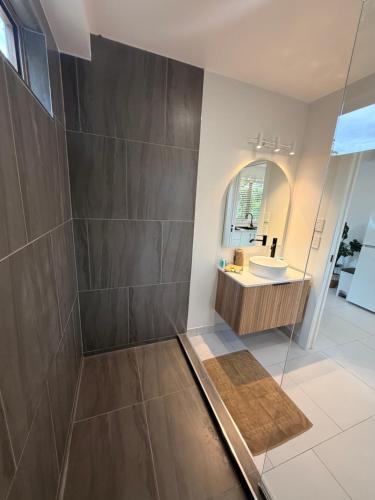 a bathroom with a shower and a sink at Muri Shores in Rarotonga