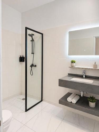 a bathroom with a shower and a sink and a mirror at Silver Apartment Abidjan in Abidjan