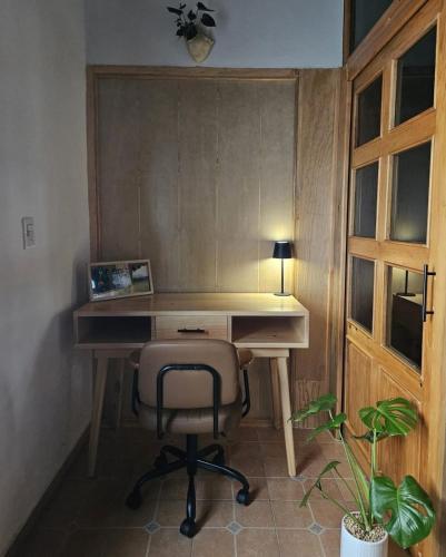 ein Schreibtisch mit Stuhl, Lampe und Pflanze in der Unterkunft Wulkan Studio in Amecameca de Juárez