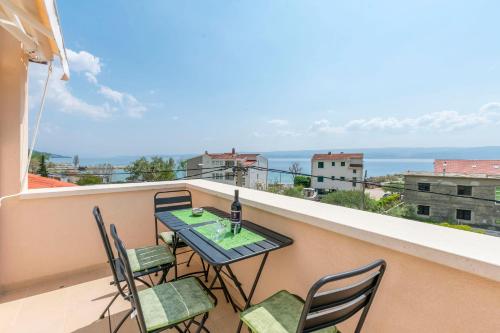 a table and chairs on a balcony with a view of the ocean at Apartments Mir in Duće