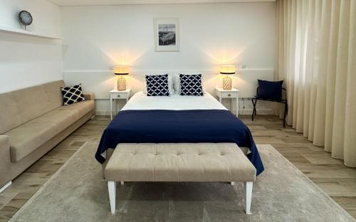 a bedroom with a bed and a couch at Pátio 29 - Guest House in Viana do Castelo