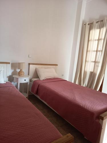a bedroom with two beds and a window at Korali in Symi