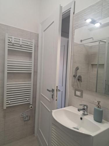 a white bathroom with a sink and a mirror at Brezza d'amare a lovely accommodation in Anzio in Anzio