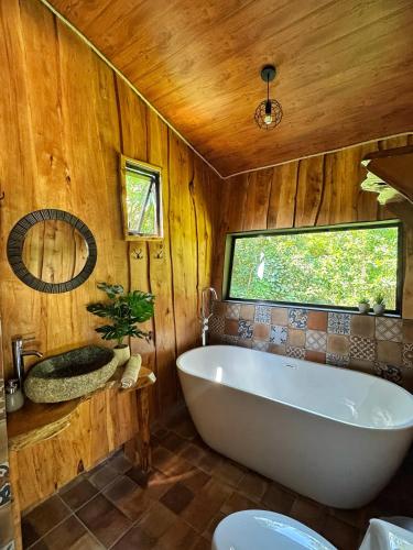 a bathroom with a large tub and a window at Poas Green Chalets in Fraijanes