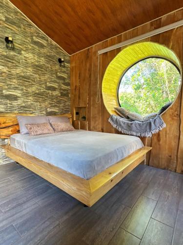 a bedroom with a bed with a round window at Poas Green Chalets in Fraijanes