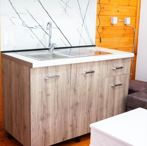 a kitchen with a sink and a wooden cabinet at Arditis Cozy Studio in Bogë