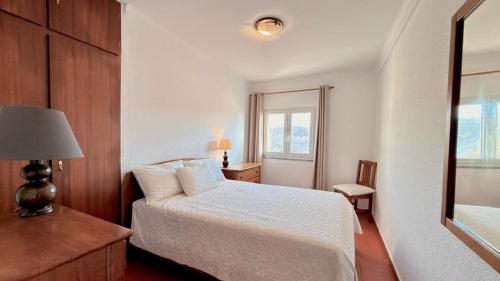 a bedroom with a white bed and a window at Apartamento sto estavão 2 in Zambujeira do Mar