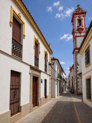 a cobblestone street in a town with a clock tower at AT Casa Pedrero in Fregenal de la Sierra