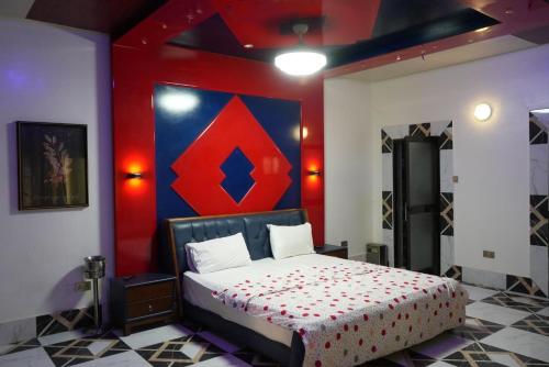 a bedroom with a bed with a red and blue wall at Zions Apartments in Elephant Island