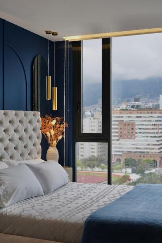 a bedroom with a bed and a large window at Cielo Apartments with top amenities in Quito