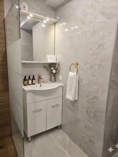 a white bathroom with a sink and a shower at Dimi Deluxe in Perea