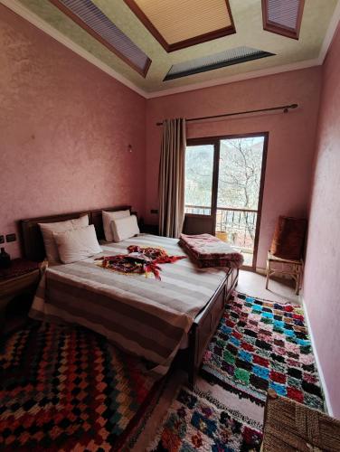 a bedroom with a bed and a large window at imlil in Imlil