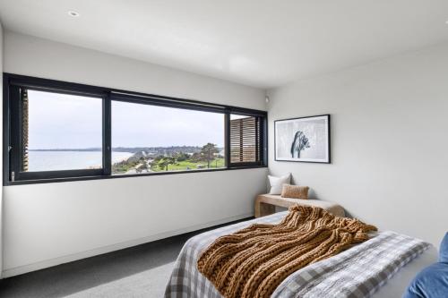 a bedroom with a bed and a large window at Emanjay - Mineral Spa, Million Dollar Views in Mount Martha