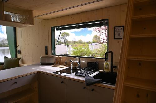 a small kitchen with a sink and a window at Tiny House Nook 1 - Green&Tiny Hideaway Eider in Süderstapel