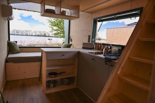a kitchen in a tiny house with a window at Tiny House Nook 2 - Green&Tiny Hideaway Eider in Süderstapel
