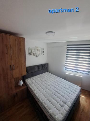 a bedroom with a bed and a wooden cabinet at Apartman Vranje in Vranje