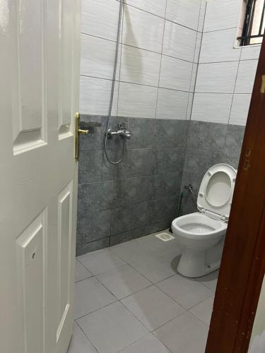 a bathroom with a toilet and a shower at St. Patrick’s Forest House in Entebbe