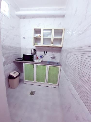 a small kitchen with a sink and a microwave at Easy Stay in Al Ain