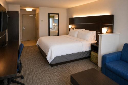 a hotel room with a large bed and a blue couch at Holiday Inn Express & Suites Hood River by IHG in Hood River