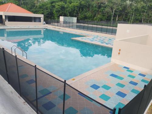 a swimming pool with blue tiles on a fence at Tangará real 204 in Apulo