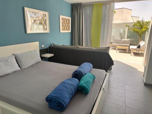 a bedroom with a bed with blue pillows on it at Casa De Pablo - Marbella Golf in Maspalomas