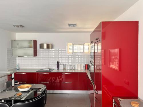 a kitchen with red cabinets and a red refrigerator at Casa De Pablo - Marbella Golf in Maspalomas