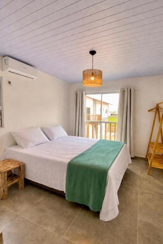 a bedroom with a large bed and a window at Casas Carole Maramar Beach House 35 e 36 in Luis Correia