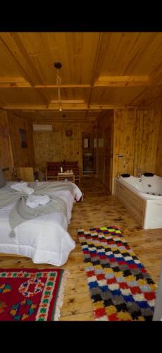 a bedroom with a bed and a tub and a rug at Afla views in Imlil