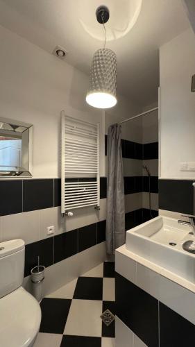 a bathroom with a black and white checkered floor at Summertime Suites in Łagów