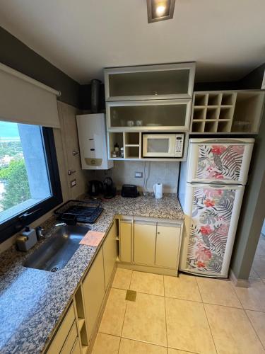 a small kitchen with a sink and a microwave at Mono Ambiente Con Vista Panorámica Zona Sur in Santiago del Estero