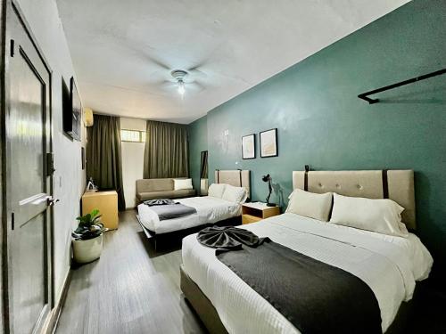 a hotel room with two beds and a couch at Jazz & Stay in Guadalajara