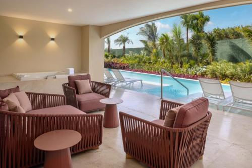 a living room with chairs and a swimming pool at Moon Palace The Grand Cancun All Inclusive in Cancún