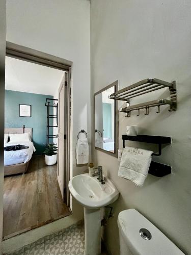 a bathroom with a sink and a mirror and a bed at Jazz & Stay in Guadalajara