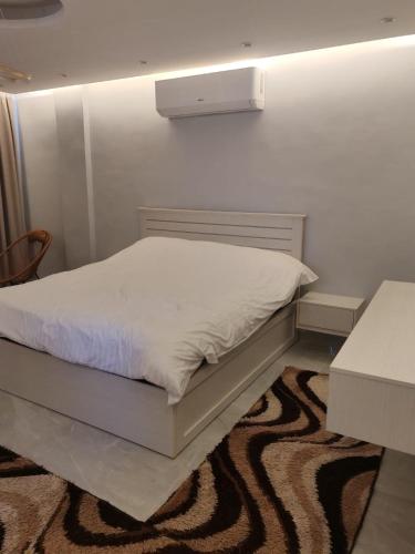 a bedroom with a white bed with a white wall at Masa villa in Ash Shāghūr