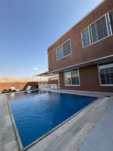 a swimming pool in front of a building at Masa villa in Ash Shāghūr