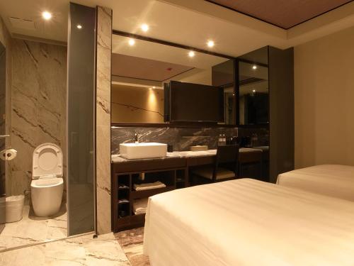 a hotel room with a bathroom with a toilet and a sink at Hotel Midtown Richardson - Kaohsiung Bo'ai in Kaohsiung