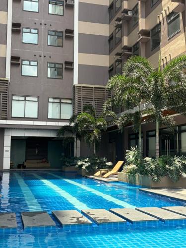 a swimming pool in front of a building at Aurora Escalades in Manila